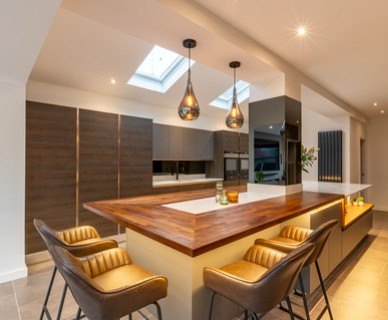 A glossy white kitchen with a curved island breakfast bar and pink strip lighting.