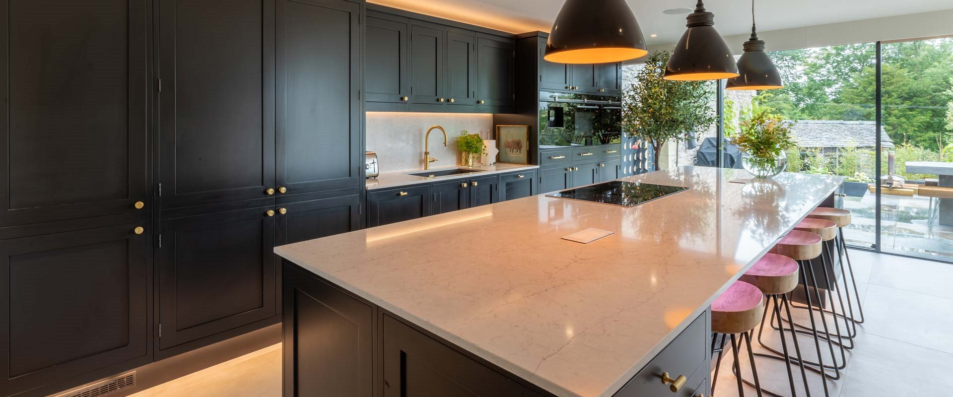 Striking ebony-coloured kitchen with white Quartz tops